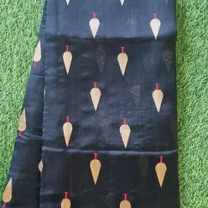 Black handloom pure silk Chanderi saree with gold leaf butti motifs and subtle zari border, displayed flat on green grass; elegant traditional silk saree.