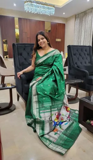 Green handloom pure silk Paithani saree with silver zari border and traditional bird motifs, worn by woman