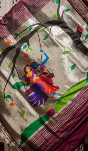 Maroon and silver handloom pure silk Paithani saree with traditional Radha Krishna swing motif and handwoven scenic artwork