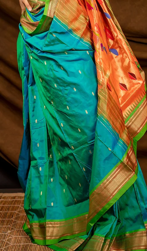 Handloom-pure-silk-paithani-3 Handloom pure silk Paithani saree with vibrant blue and orange colors, featuring intricate patterns and gold detailing.