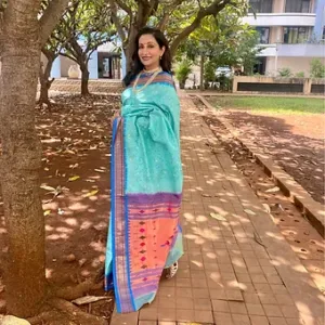 Woman wearing a handloom pure silk Paithani saree with bandhani design, featuring vibrant colors and intricate patterns.