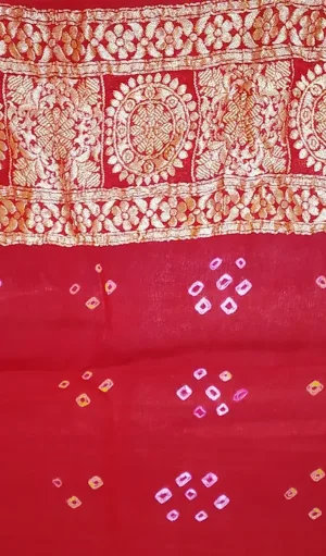 Handwoven Pure Chiffon Banarasi saree in deep red with intricate gold zari border featuring floral and geometric patterns. The saree is further embellished with delicate diamond-shaped motifs in gold and pink, offering a blend of traditional elegance