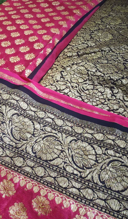 Handwoven-Pure-Georgette-Banarasi-Saree-6 Handwoven pure georgette Banarasi saree featuring intricate gold floral patterns on a black background with a contrasting pink border.