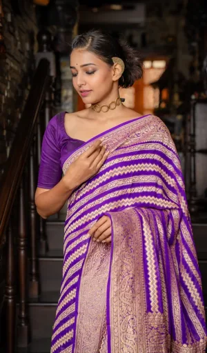 Woman wearing a purple saree with intricate golden patterns, standing gracefully on a staircase.