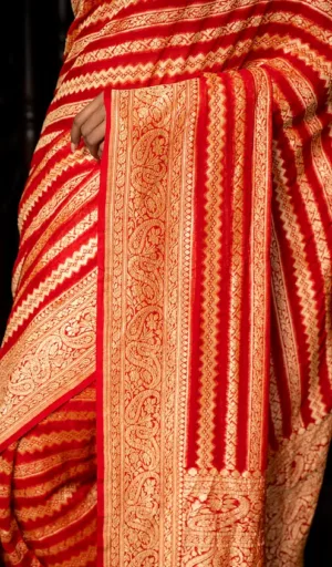 Handwoven pure khaddi georgette saree with intricate gold and red patterns, showcasing detailed embroidery and a rich texture.