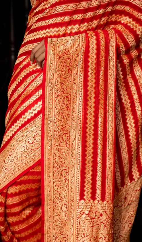 Handwoven-Pure-Khaddi-Georgette-banarasi-1 Handwoven pure khaddi georgette saree with intricate gold and red patterns, showcasing detailed embroidery and a rich texture.