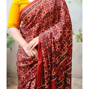 A woman wearing a red Ajarakh handblock printed saree with intricate patterns, paired with a yellow blouse.