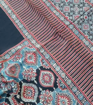 Modal silk Ajrakh block printed saree featuring intricate red, blue, and white floral patterns with striped borders and traditional geometric designs, in a rich navy blue color.