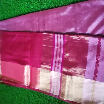 Pink Mulberry Silk Maheshwari Saree with Glossy Zari Pallu Close view of a mulberry silk Maheshwari saree featuring rich shades of magenta, pink and lavender with glossy zari pallu and pastel beige border, displayed on a green grass background.