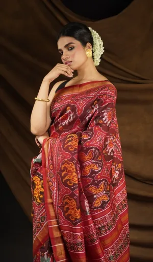 Woman wearing maroon mulberry silk handcrafted single ikat Patola saree with traditional animal and geometric motifs