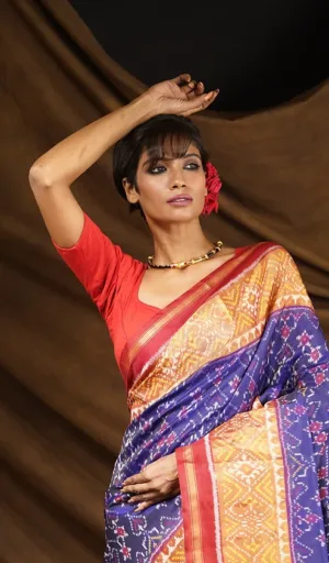 Woman wearing blue mulberry silk handcrafted single ikat Patola saree with red and gold woven border
