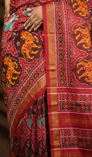 Mulberry silk handcrafted single ikat Patola saree in maroon and red with traditional animal motifs and woven border