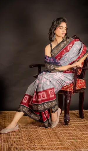 Woman wearing grey handloom Odisha ikat cotton saree with red and black traditional woven motifs