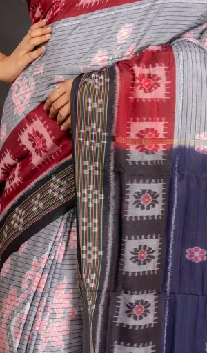 Woman wearing grey handloom Odisha ikat cotton saree with red, black, and navy woven motifs
