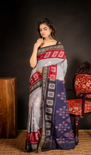 Woman wearing grey handloom Odisha ikat cotton saree with red and navy traditional woven motifs