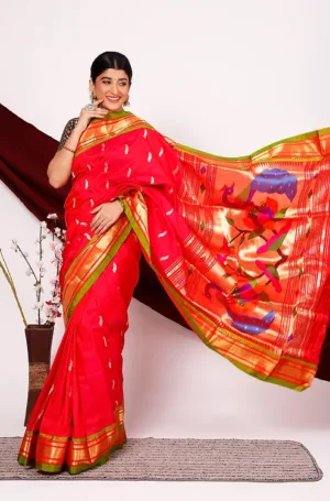 Red handloom pure silk Paithani saree with green and gold zari border and traditional peacock pallu, worn by woman