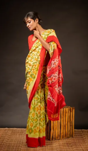 Woman wearing single ikat pure cotton saree in yellow and green with red contrast pallu