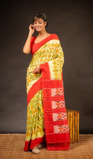 Woman wearing single ikat pure cotton saree in yellow and green with red woven pallu