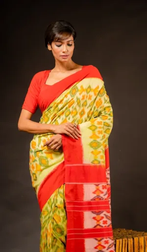 Woman wearing single ikat pure cotton saree in yellow and green with red contrast border
