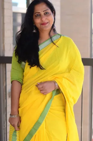 Yellow handloom cotton Mangalagiri saree with green border, worn by woman in elegant traditional style